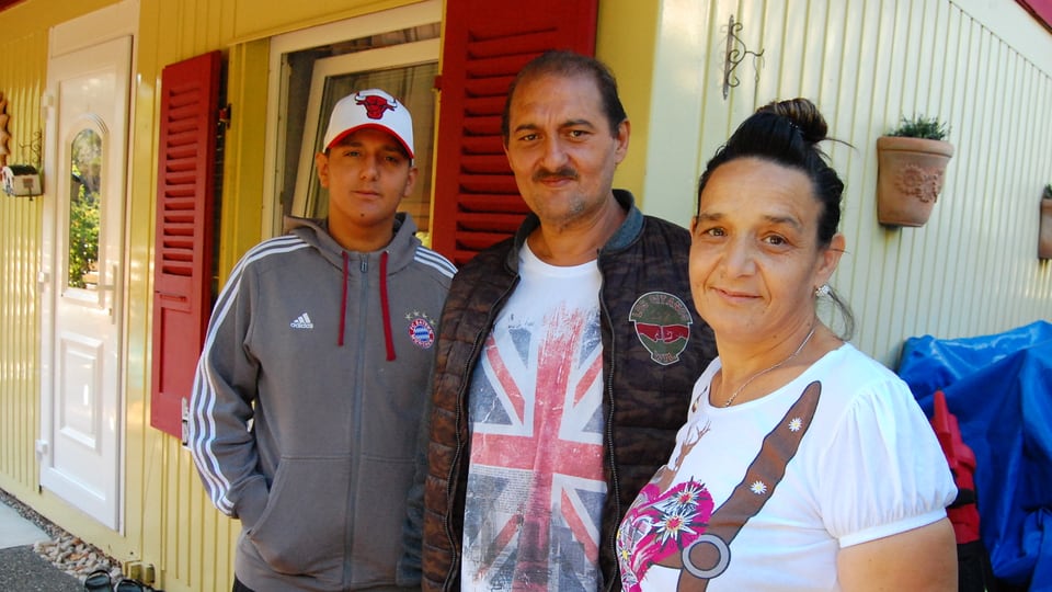 Familie vor einem kleinen Haus