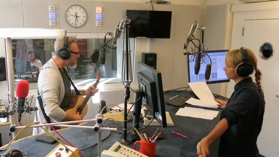 Blick ins Radiostudio mit Musiker Baum, der die Gitarre umgehängt hat und ein Lied singt. 