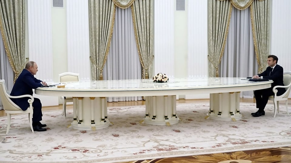 Putin und Macron sitzen an den Kopfenden eines sehr langen Tisches.