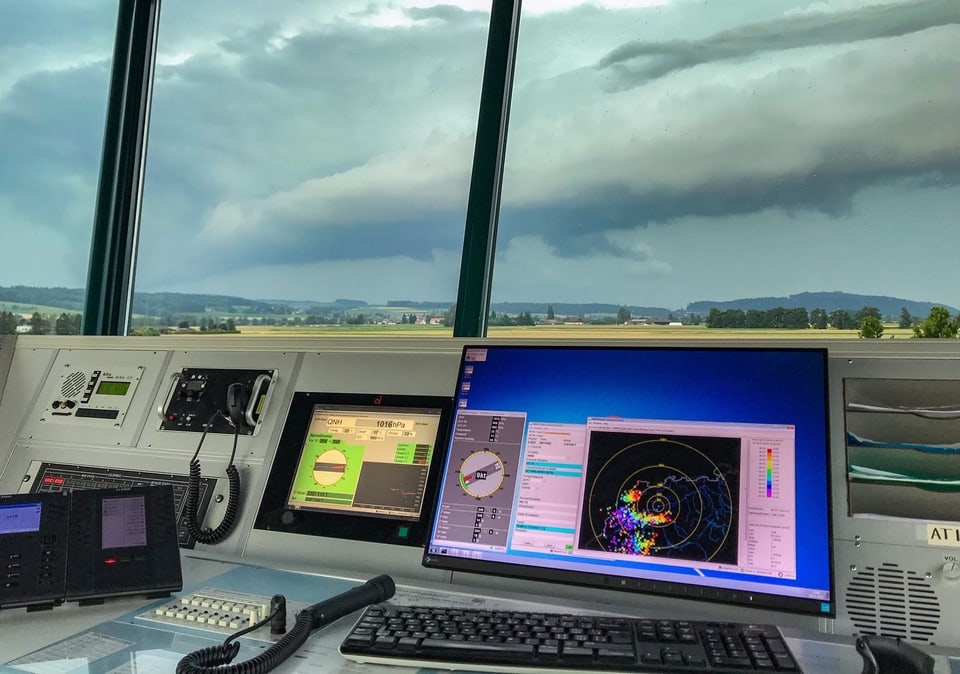 Blick aus dem Kontrollturm auf die Gewitterwolken und den Wetterradar auf einem PC-Bildschirm