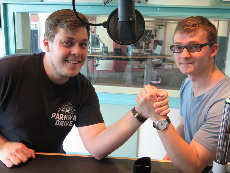 Zwei Jungpolitiker beim Armdrücken im Radiostudio