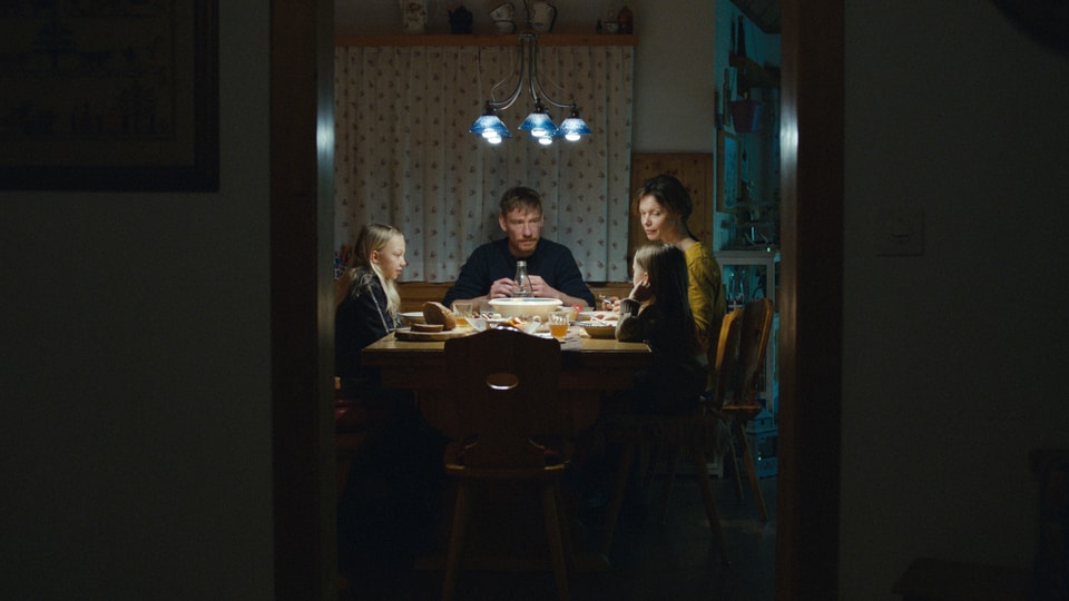 Eine Familie sitzt am Esstisch.