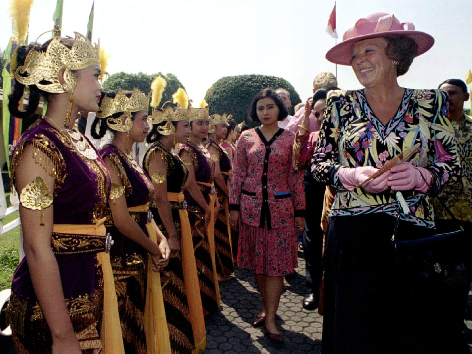Beatrix schreitet ein Spalier von traditionellen indonesischen Tänzerinnen ab.