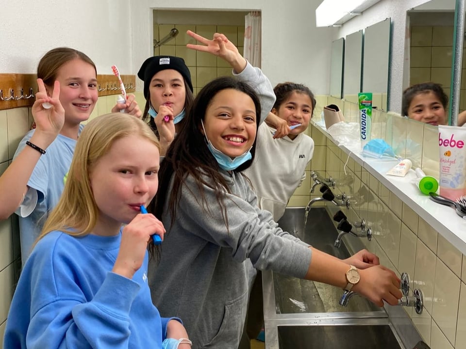 Fünf Mädchen stehen im Waschsaal und putzen ihre Zähne