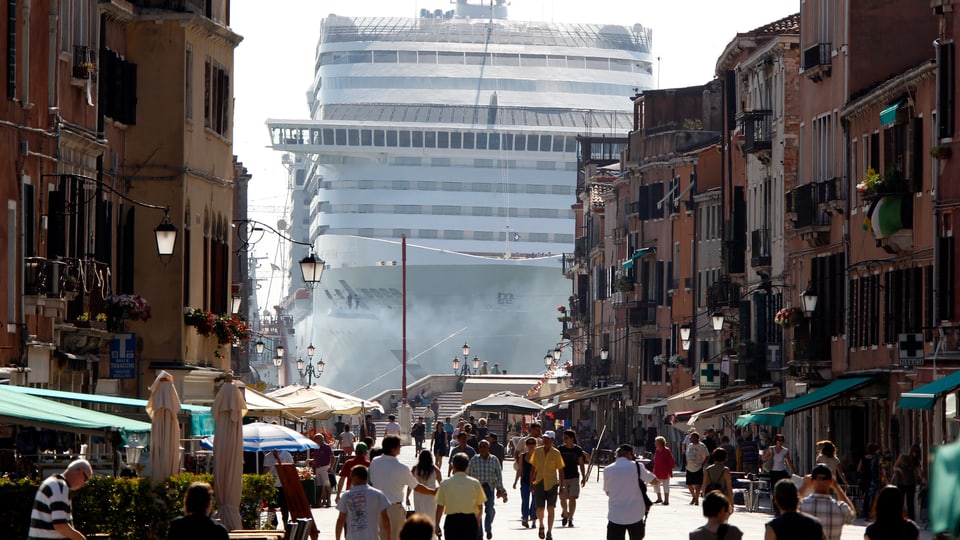 Ein riesiges Kreuzfahrtschiff am Ende einer Gasse in Venedig.