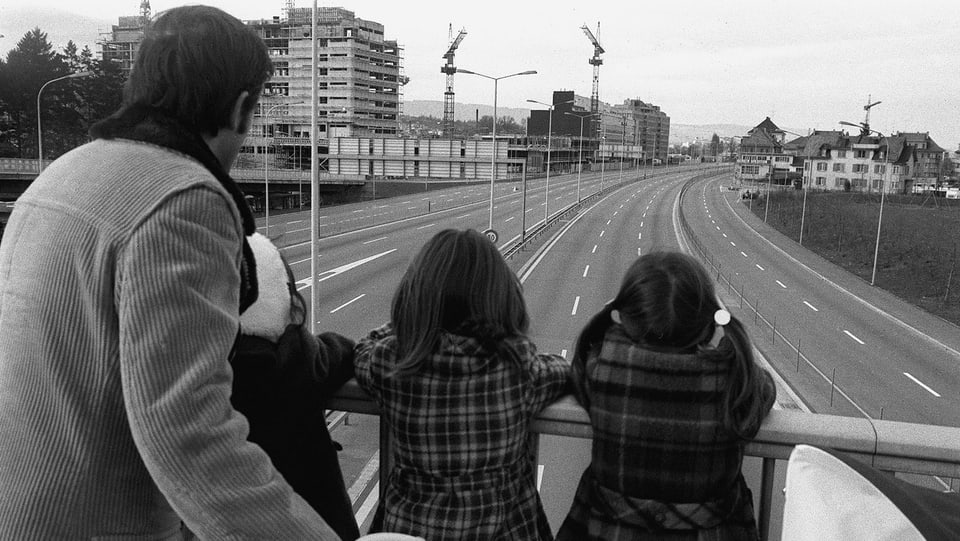 Mann mit Mädchen auf einer Brücke über einer leeren Schnellstrasse