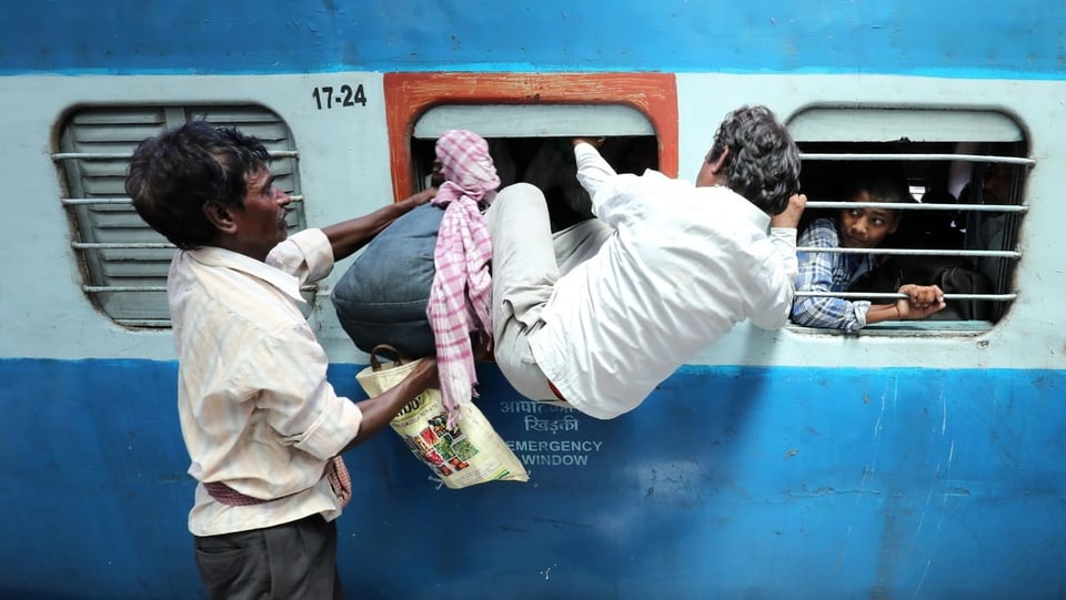 Mann steigt durch Fenster in einen Zug ein