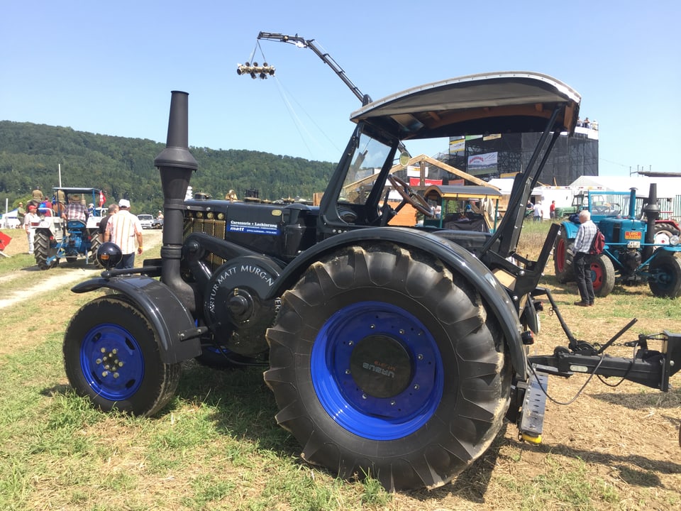 Ein eleganter Traktor in schwarz mit blauen Felgen