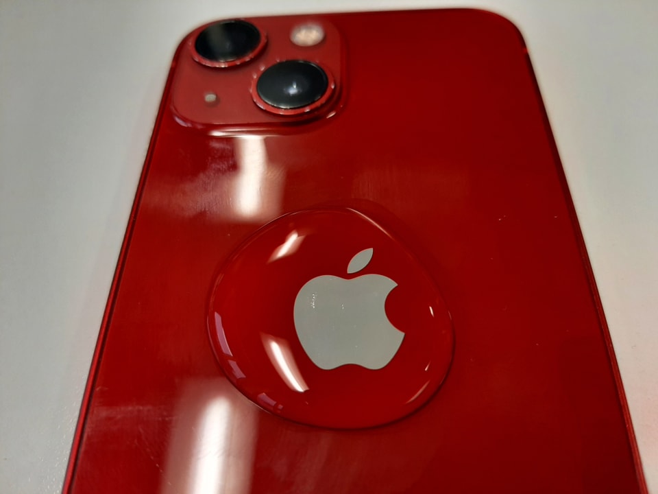Ein rotes iPhone mit einem Wassertropfen