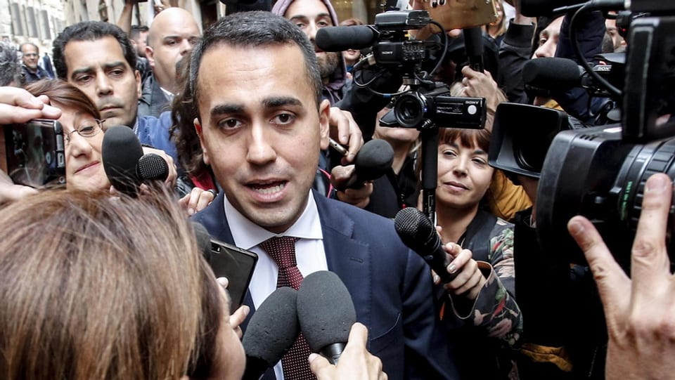 Di Maio umringt von Journalisten mit Kameras.