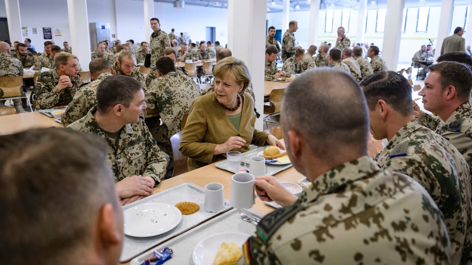 Die deutsche Bundeskanzlerin Angela Merkel isst mit Soldaten in Afghanistan.