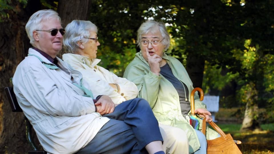 Seniorinnen und Senioren auf einer Parkbank.