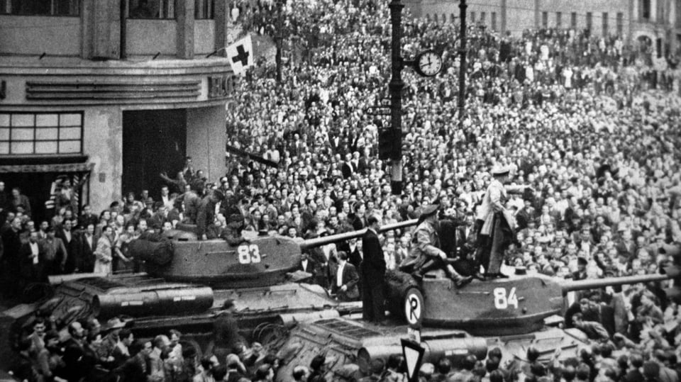 Schwarzweiss-Bild: Panzer steht inmitten einer Menschenmenge.