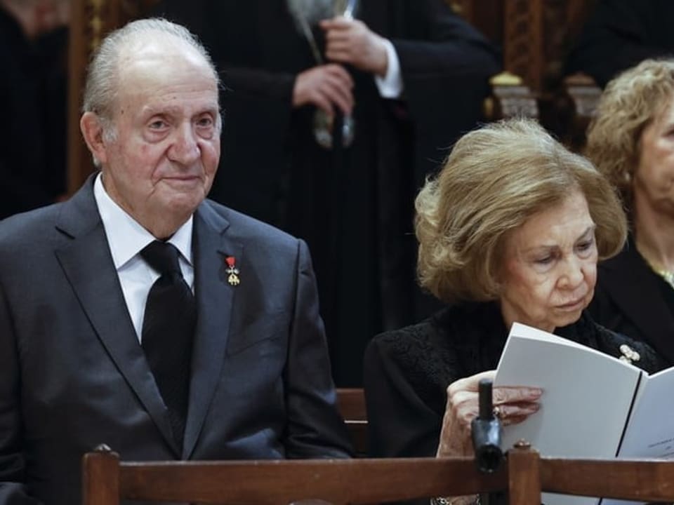 Juan Carlos und Sofia in einer Kirchenbank sitzend.