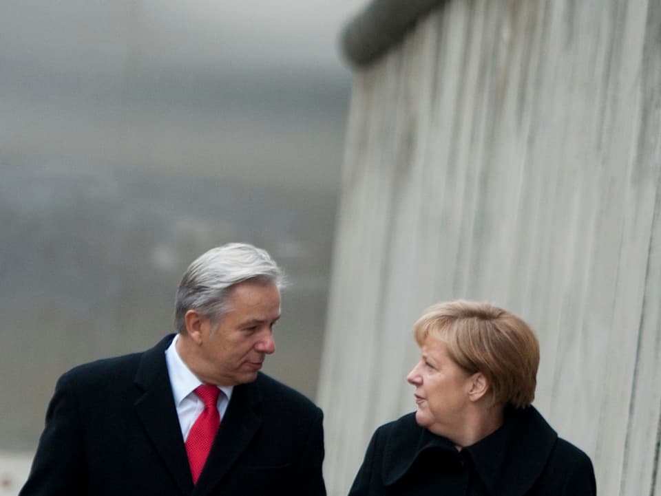 Wowereit und Angela Merkel laufen einem Abschnitt der einstigen Berliner Mauer entlang.