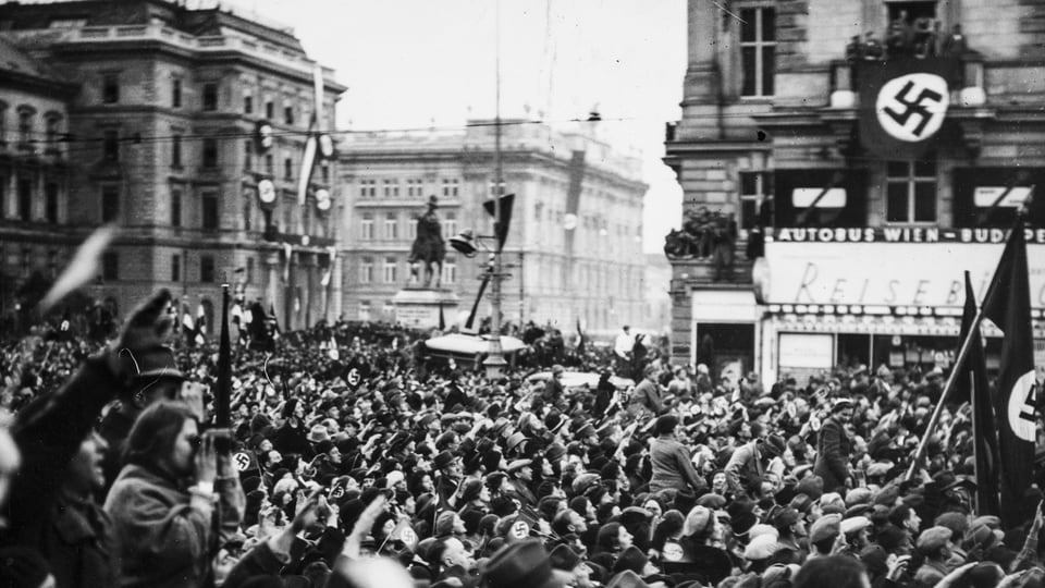 Menschenmenge bejubeln mit Hakenkreuzfahnen Nationalsozialisten.