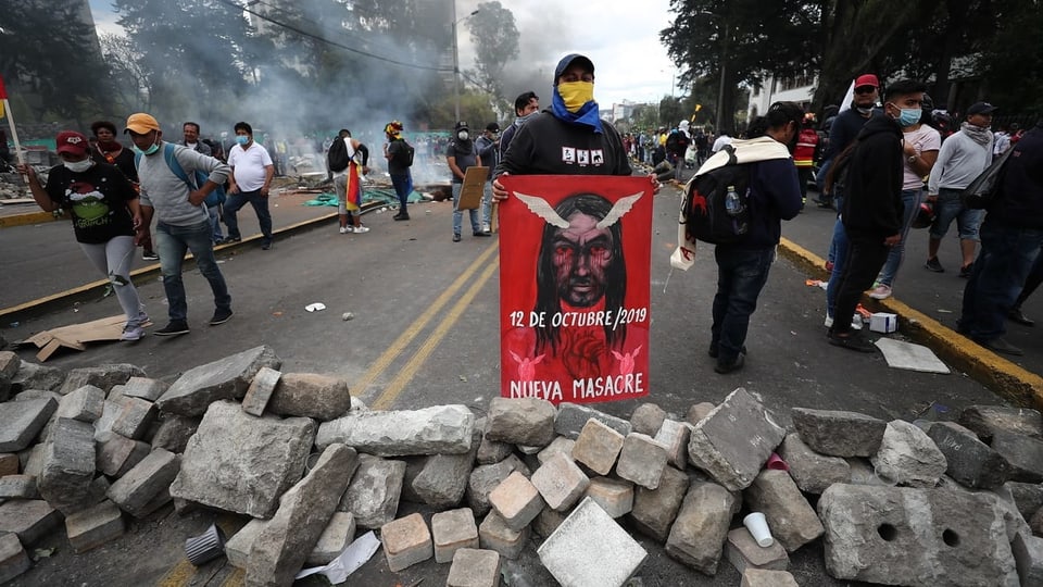 Demonstrant hinter Steinbarrikade mit Protestschild