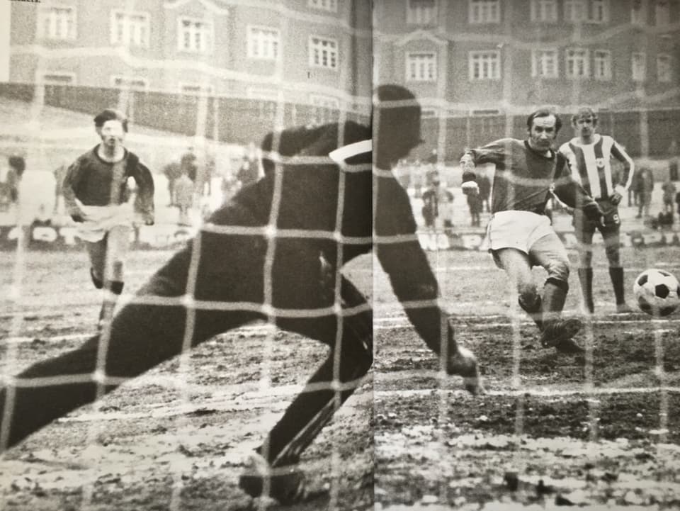 Ein Foto eines Fotos eines alten Spiels zeigt den Goalie in Schwarz/Weiss und den Stürmer, der schiesst.