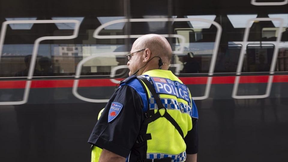 Stämmiger Bahnpolizist mit Glatze beobachtet Zug aus Österreich