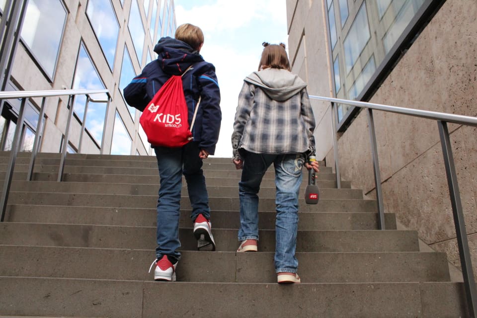 Rückenansicht eines Jungen und Mädchens, die eine Treppe hinaufsteigen 