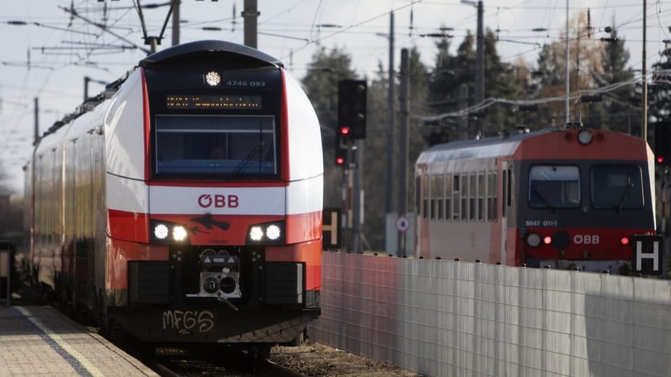 Rot-weisser ÖBB-Zug an einem Bahnhof
