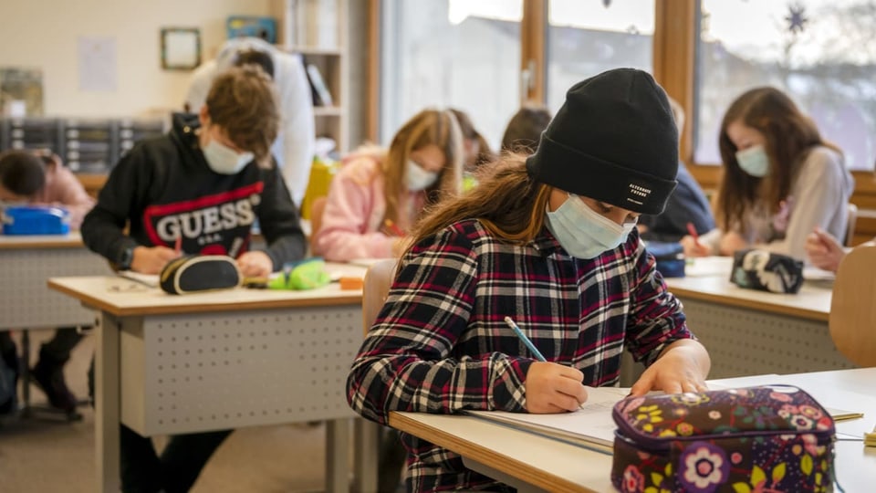 Kinder tragen Maske im Schulzimmer