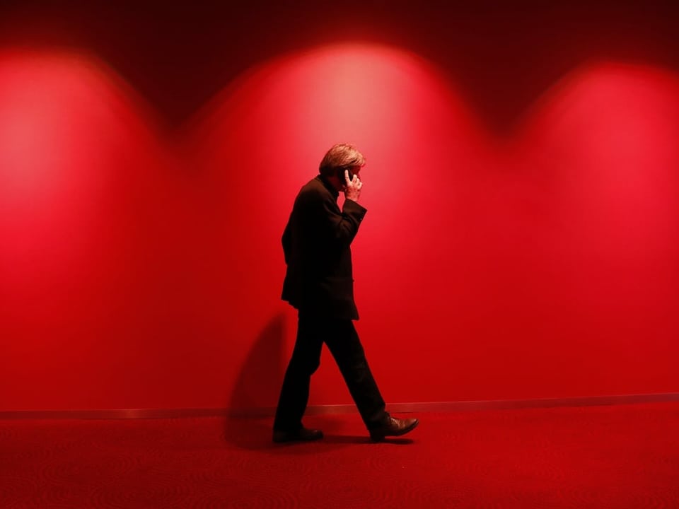Paul Rechsteiner telefoniert vor roter Wand