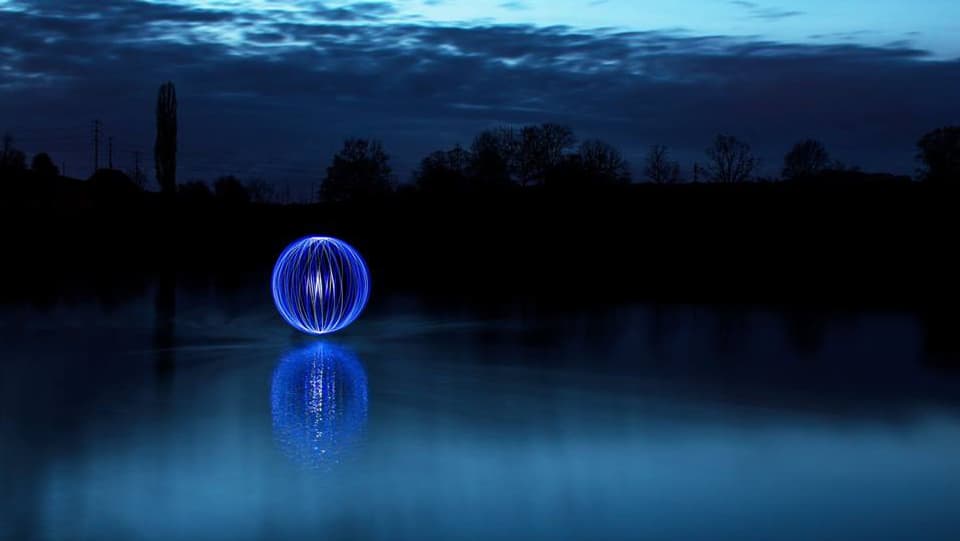 Nachtaufnahme von einem See mit geometrischer Figur.