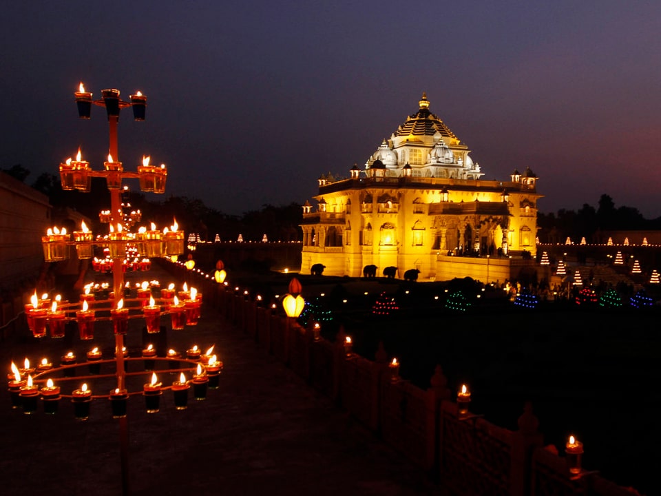 Lichtbestrahlter Tempel mit Kerzen im Vordergrund