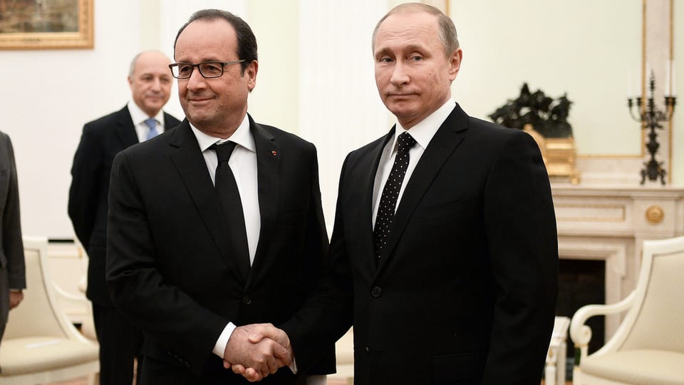 Hollande und Putin reichen sich die Hand, sehen sich dabei aber nicht an. Putin verzieht das Gesicht. 