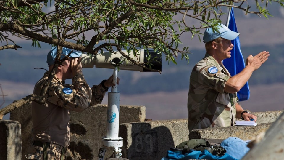 Zwei UNO-Soldaten überwachen mit einem Fernglas die Lage an der Grenze zu Syrien.