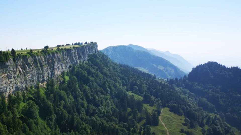 Klippe, daneben bewaldete Hügel