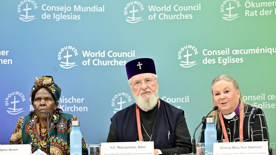 Drei Geistliche sitzen an einer Pressekonferenz im Rahmen der Vollversammlung des Ökumenischen Kirchenrats.