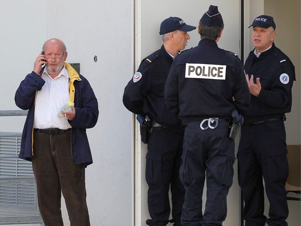 Jean-Claude Mas und drei Polizisten während einer Pause des Prozesses.