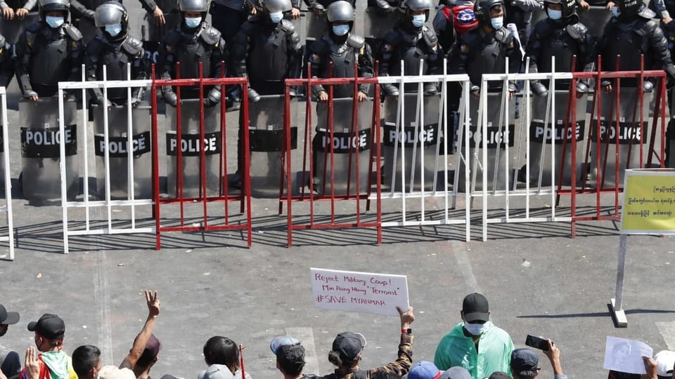 Protestierende stehen der Polizei in Myanmar gegenüber.