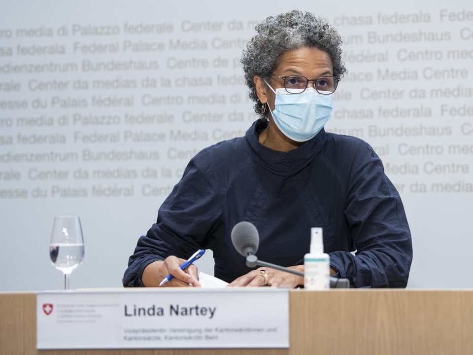 Linda Nartey mit Atemschutzmaske an einer Pressekonferenz