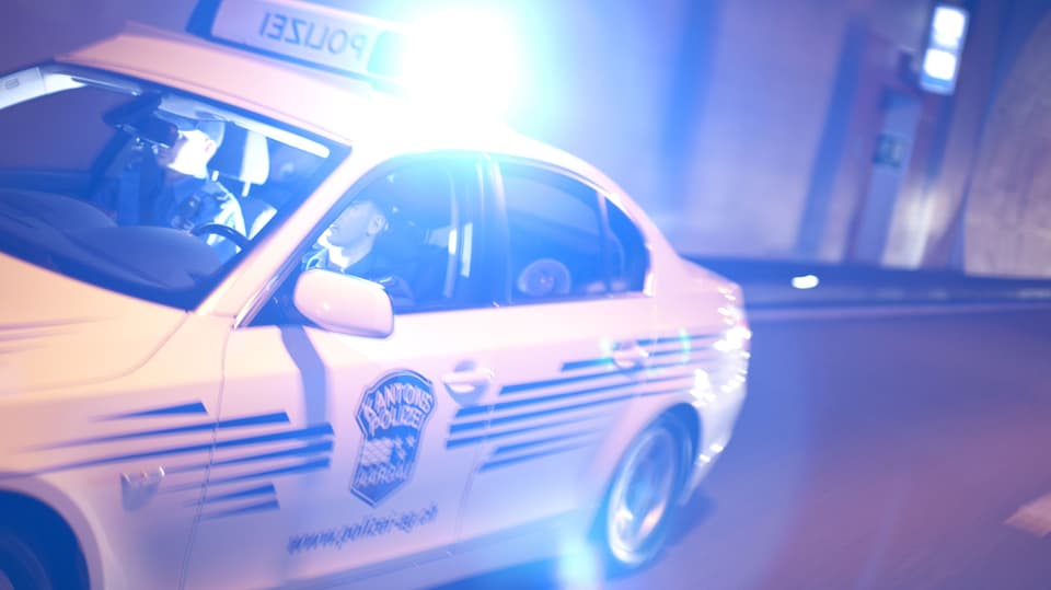 Ein Auto der Kantonspolizei Aargau mit Blaulicht im Dunkeln.