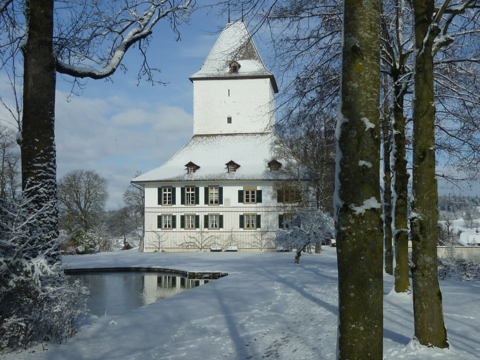 Ein Schloss in verschneiter Landschaft. 