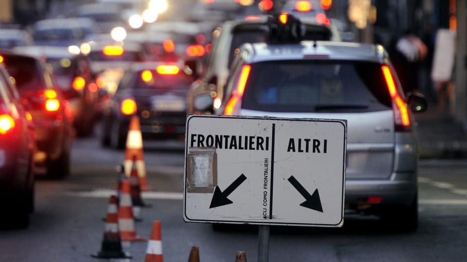Autoschlange am Grenzübergang in Como, Schild trennt Grenzgänger, «Frontalieri», von «anderen».