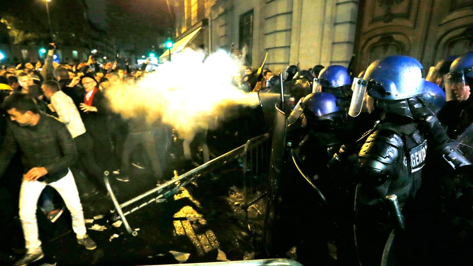 Französische Polizisten versprühen anlässlich der Präsidentschaftswahlen in Rumänien Tränengas in eine aufgebrachte Menge von Demonstranten, in Paris vor der rumänischen Botschaft.