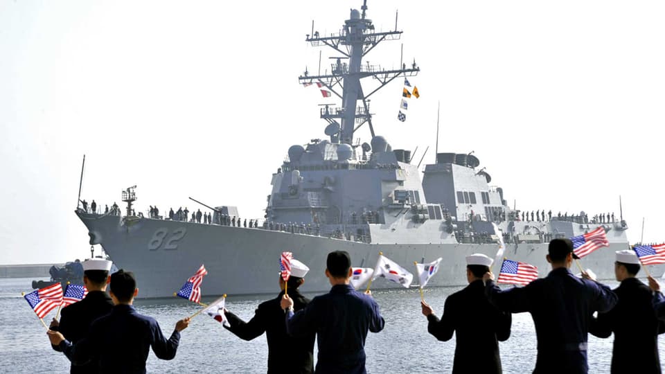 Südkoreanische Marine-Soldaten begrüssen ein US-Kriegsschiff am Hafen in Donghae. Sie schwenken südkoreanische und US-Flaggen.