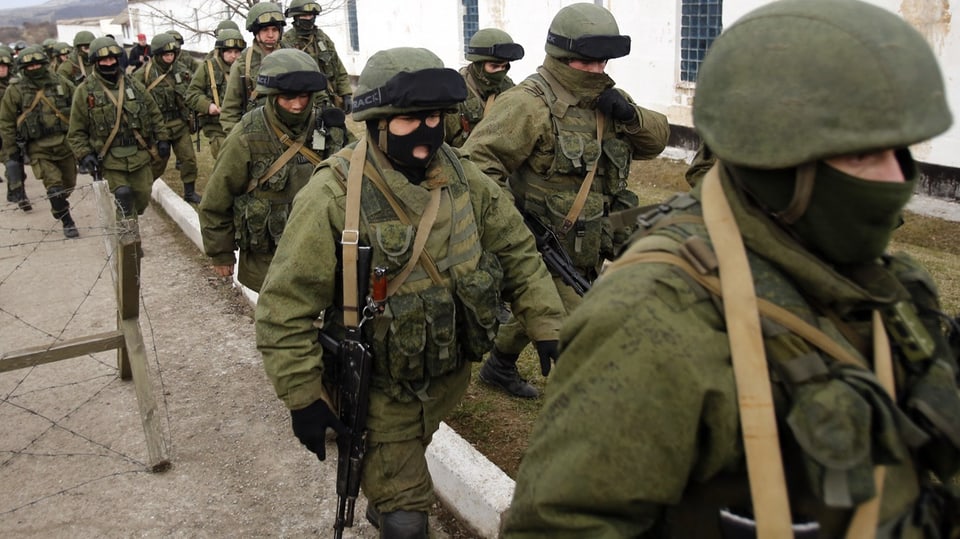Männer in Uniformen ohne Abzeichen schirmen ukrainischen Stützpunkt auf der Krim ab, März 2014 