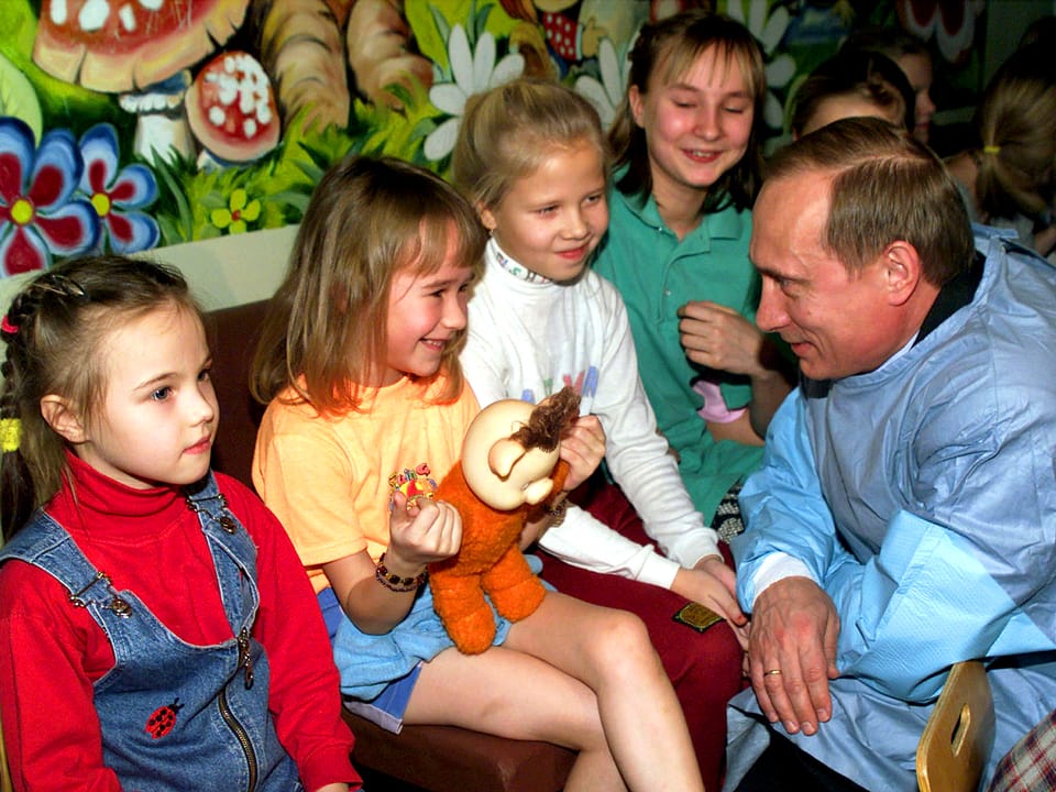 Putin kniet vor vier Mädchen, die ihn anlachen. (12.1.00)