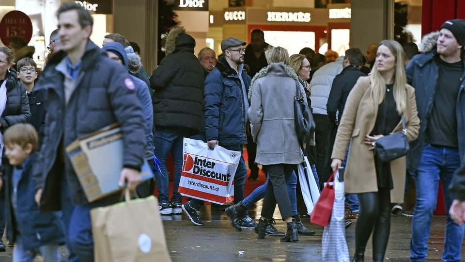 Menschen auf Einkaufsstrasse mit Taschen
