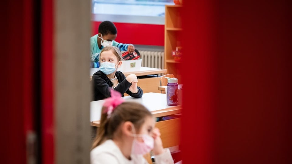 Kinder der ersten Klasse der Grundschule von Chiasso im Klassenzimmer mit Schutzmaske.