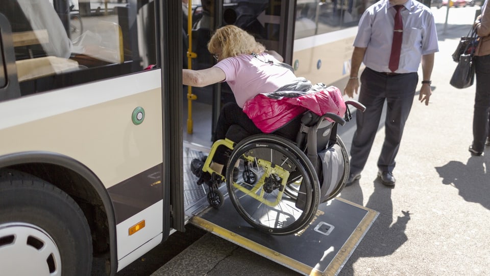 Frau im Rollstuhl vor Bus