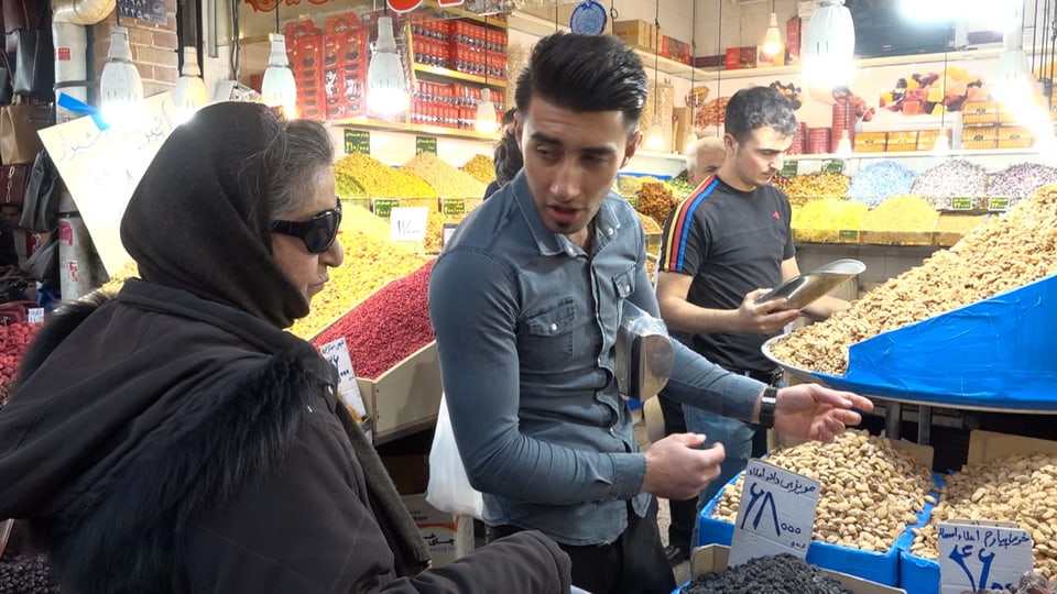 Eine Frau und ein Mann feilschen im Grossen Basar von Teheran.