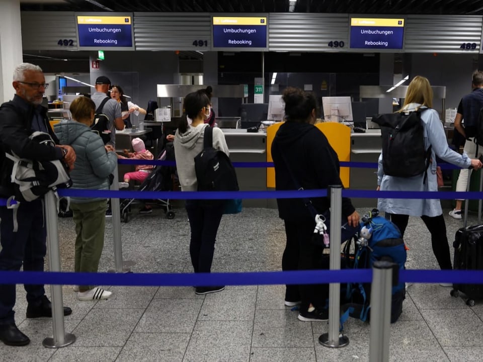 Passagiere der deutschen Fluggesellschaft Lufthansa warten vor den Umbuchungsschaltern.