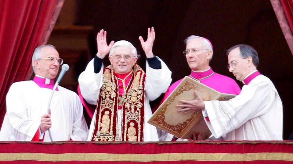 Papst auf dem Balkon des Petersdoms mit erhobenen Händen.