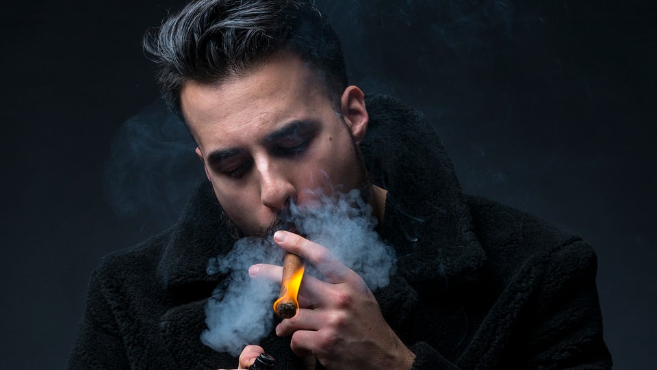 Der Rapper Don Fuego entzündet eine Zigarre